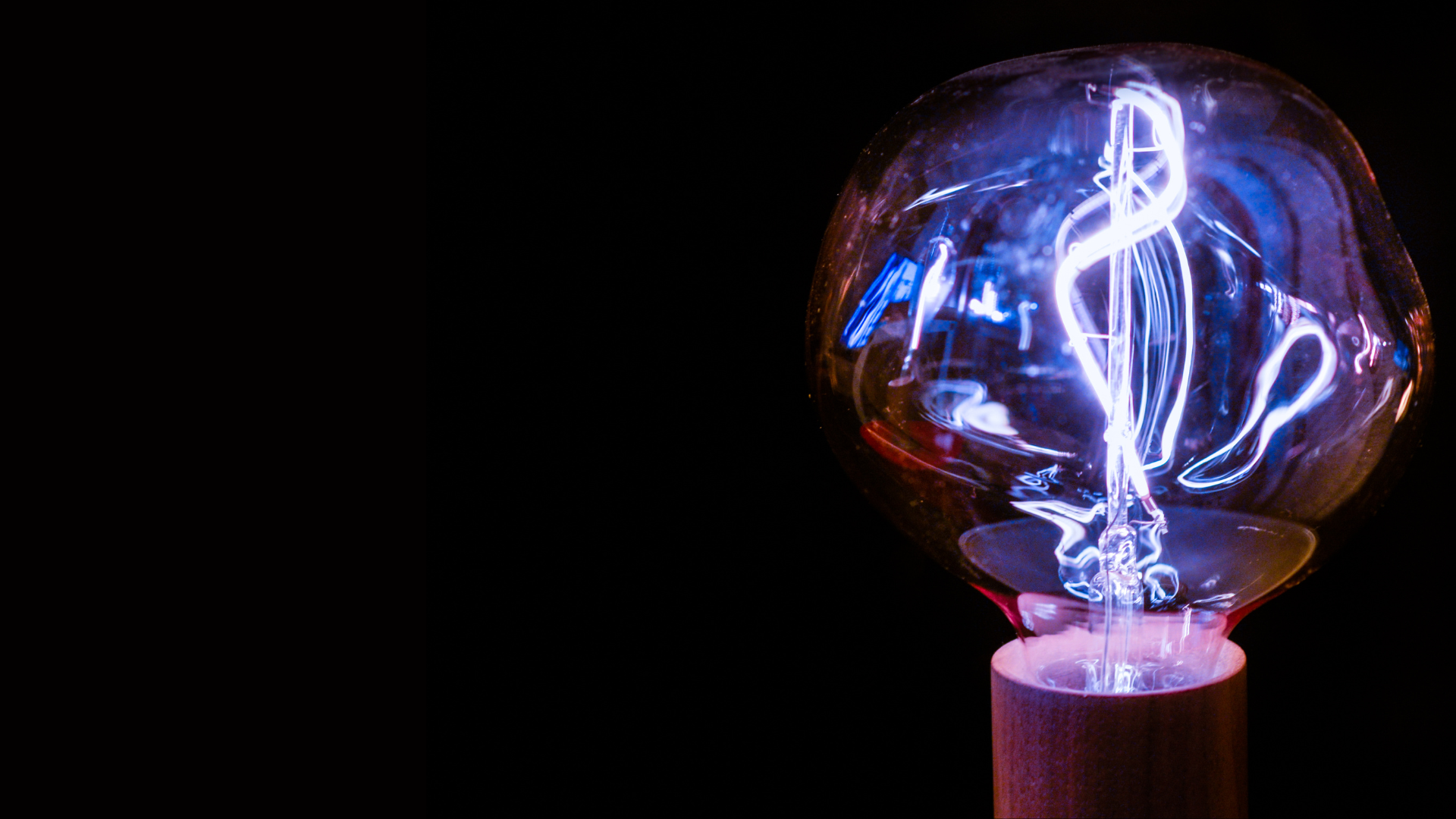 Light bulb with blue light against a black background
